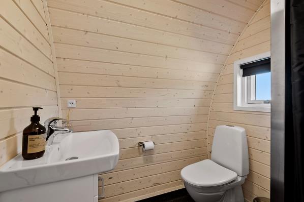 Stort badeværelse med brus og toilet
